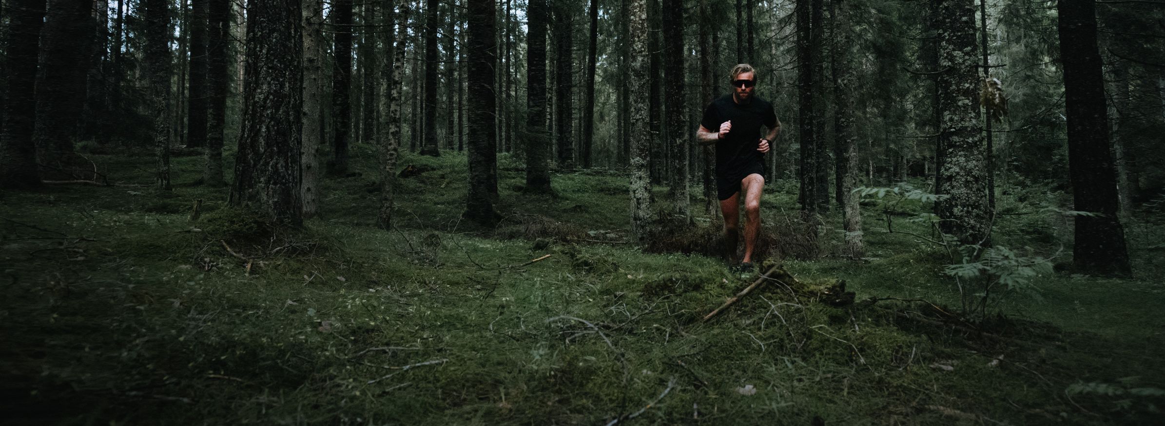 Mann som løper terrengløp i skogen